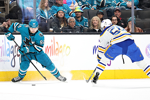 Sharks forward Alexander Barabanov (94) attempts to skate around Eric Robinson (right)