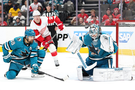 Sharks goalie Kaapo Kahkonen (36) stops a shot on goal as defenseman Mario Ferraro (38) provides support