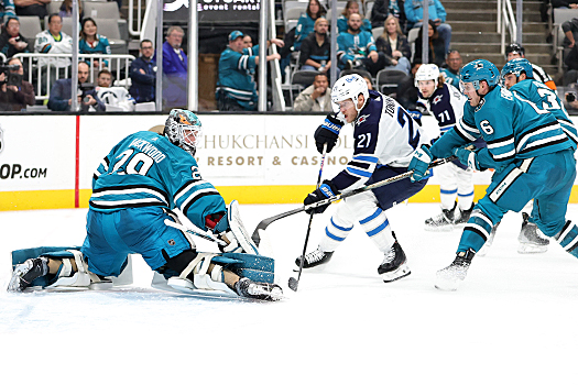 Sharks goalie Mackenzie Blackwood stops a shot by Dominic Toninato (21) as defenseman Ty Emberson (6) attempts to block the shot