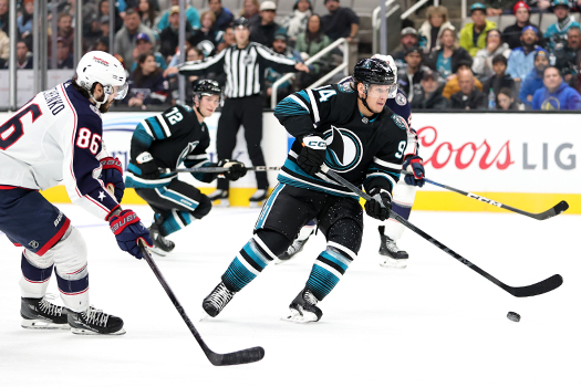 Sharks forward Mikael Granlund (64) skates towards the net in front of Boone Jenner (38)