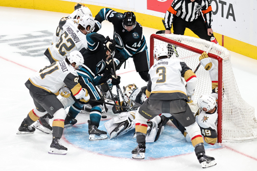 William Eklund (center) attempts to dig the puck out of a scrum of players in front of the Vegas net