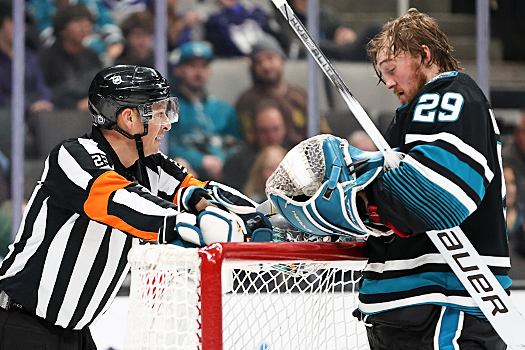 Referee Ghislain Hebert talks to Sharks goalie Mackenzie Blackwood during a stoppage in play