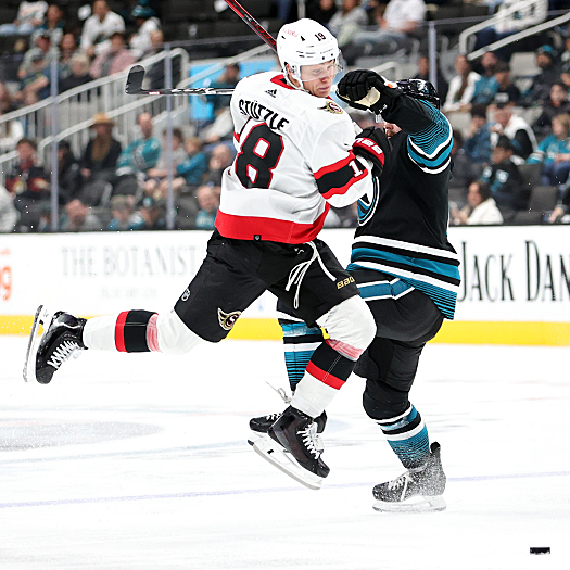 Senators center Tim Stutzle (18) attempts to move past Sharks defenseman Kyle Burroughs