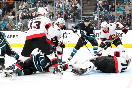 Senators goalie Joonas Korisalo (70) covers the puck in the middle of a scrum of players