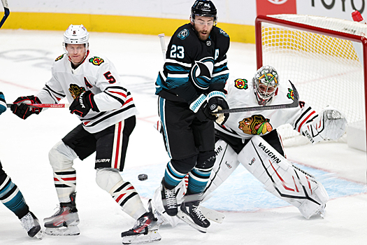 Sharks Barclay Goodrow (23) jumps to avoid being hit by a shot as Connor Murphy (5) defends in front of goalie Petr Mrázek